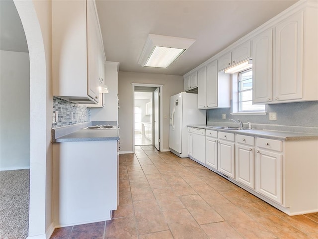 kitchen featuring decorative backsplash, light tile patterned floors, white cabinetry, and sink