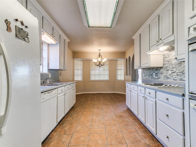 kitchen with white cabinets, white appliances, decorative light fixtures, and sink