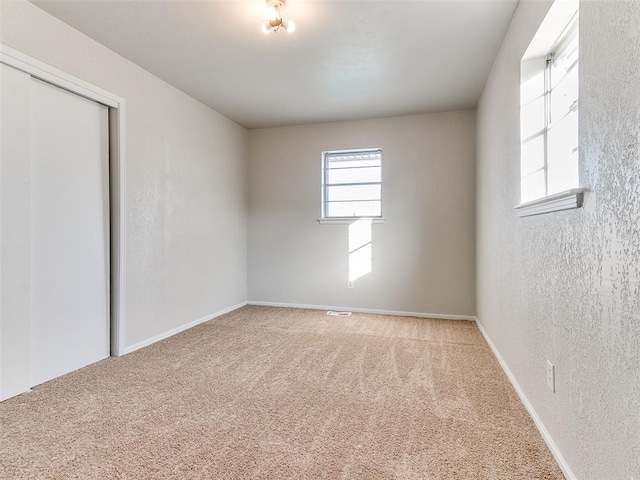 unfurnished bedroom featuring carpet flooring and a closet