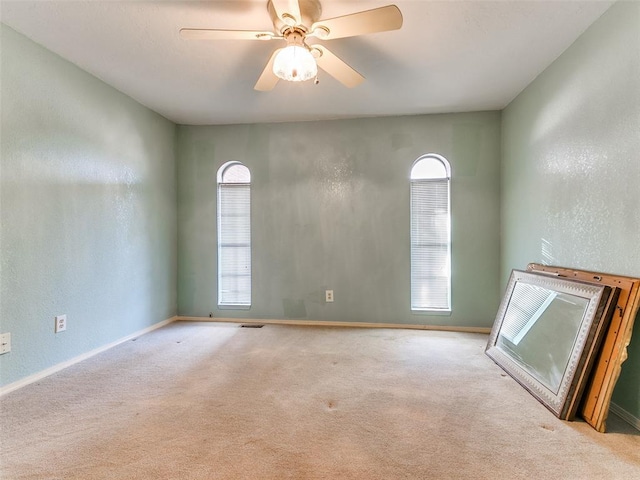 spare room featuring ceiling fan and light colored carpet