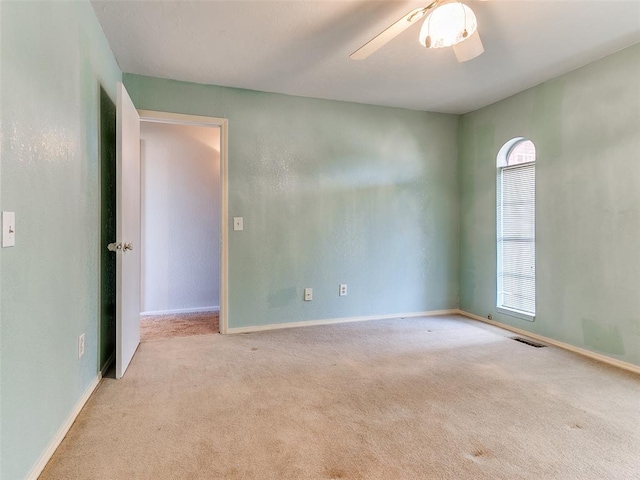 spare room with ceiling fan and light colored carpet