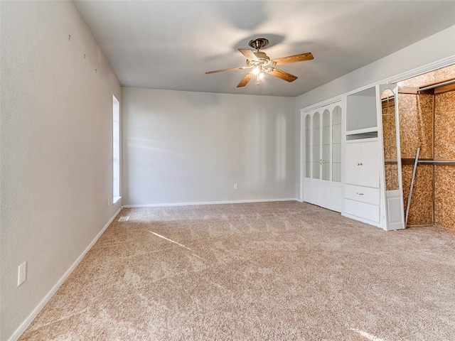 unfurnished bedroom with ceiling fan and light colored carpet