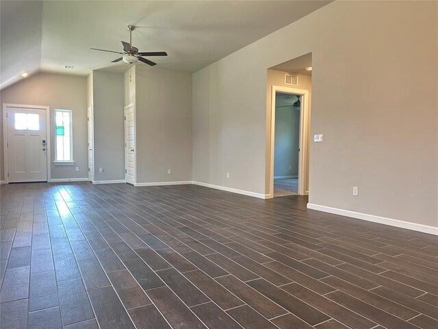 unfurnished living room featuring ceiling fan, dark hardwood / wood-style flooring, and vaulted ceiling