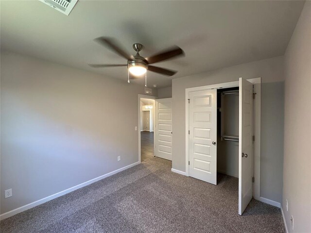 unfurnished bedroom featuring dark colored carpet, a closet, and ceiling fan