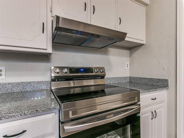 kitchen featuring stainless steel electric stove and white cabinetry