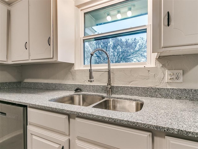 kitchen with white cabinets, plenty of natural light, dishwasher, and sink