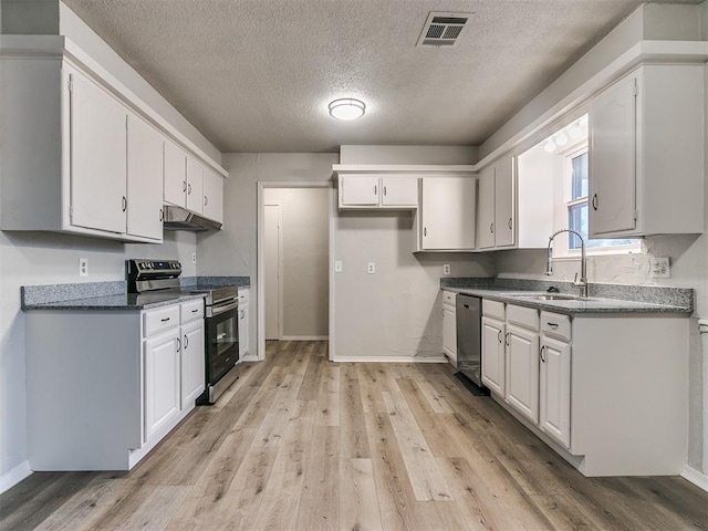 kitchen with sink, stainless steel appliances, light hardwood / wood-style floors, a textured ceiling, and white cabinets