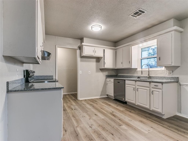 kitchen with sink, a textured ceiling, light hardwood / wood-style floors, white cabinetry, and stainless steel appliances