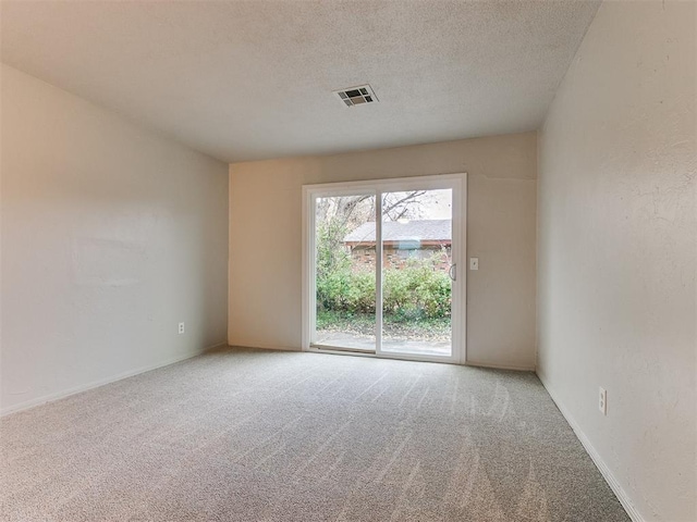 carpeted spare room featuring a textured ceiling