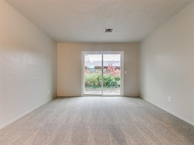 carpeted empty room featuring a textured ceiling