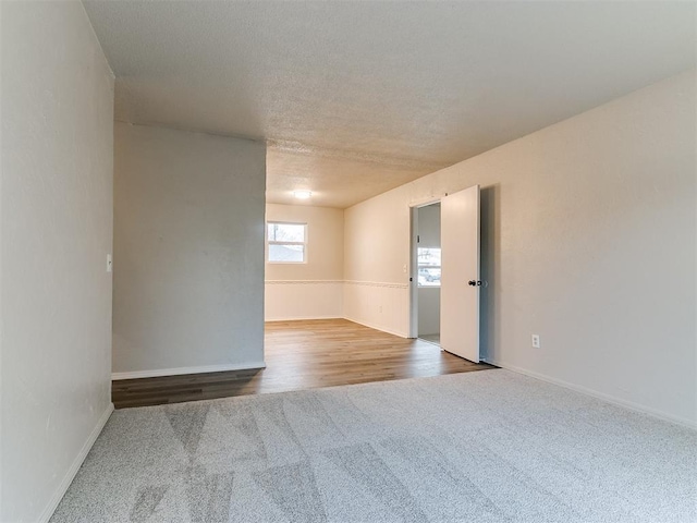 empty room with hardwood / wood-style flooring and a textured ceiling