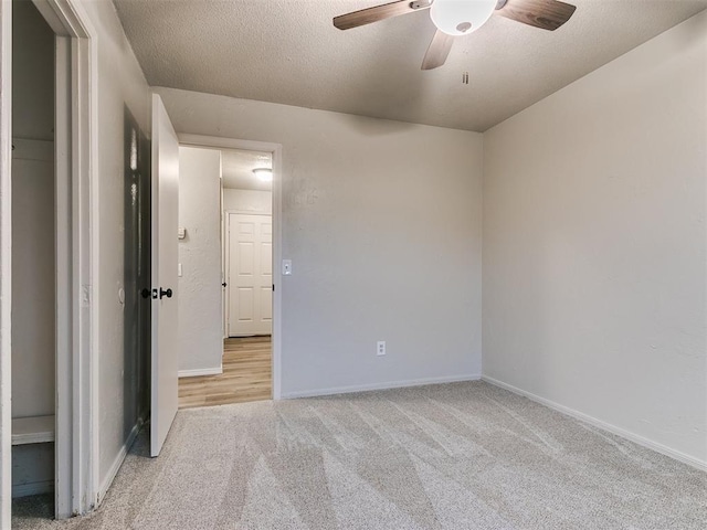 carpeted empty room with ceiling fan and a textured ceiling