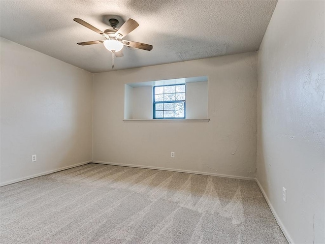 spare room featuring carpet flooring, ceiling fan, and a textured ceiling