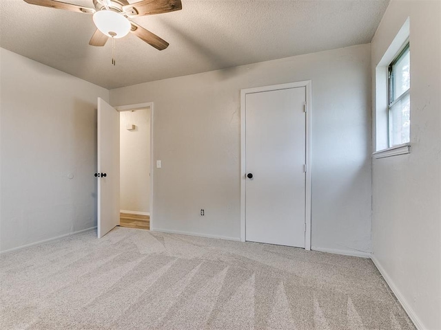 carpeted empty room with a textured ceiling and ceiling fan