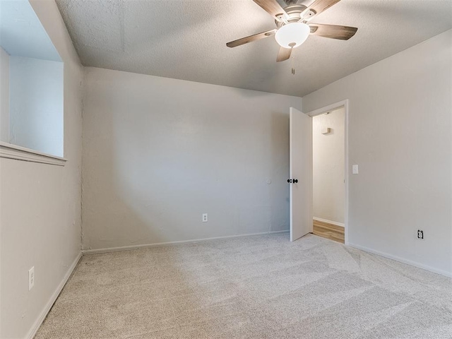 carpeted spare room featuring a textured ceiling and ceiling fan