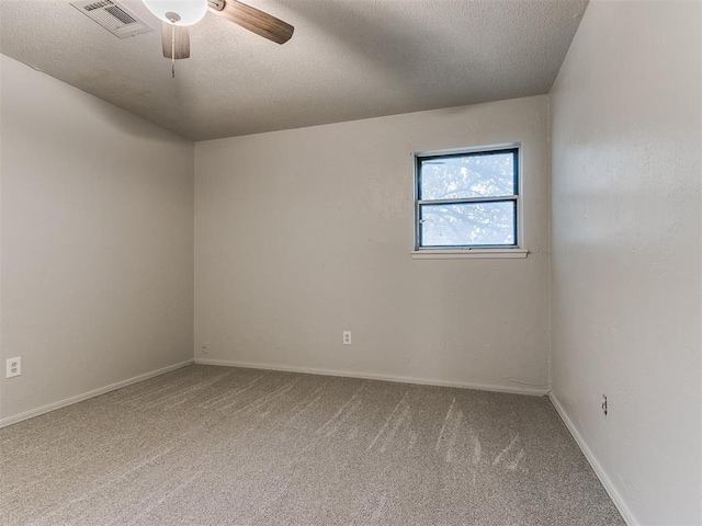 spare room with a textured ceiling, carpet floors, and ceiling fan