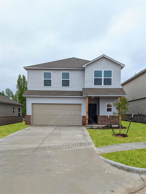 view of front of home with a garage and a front lawn