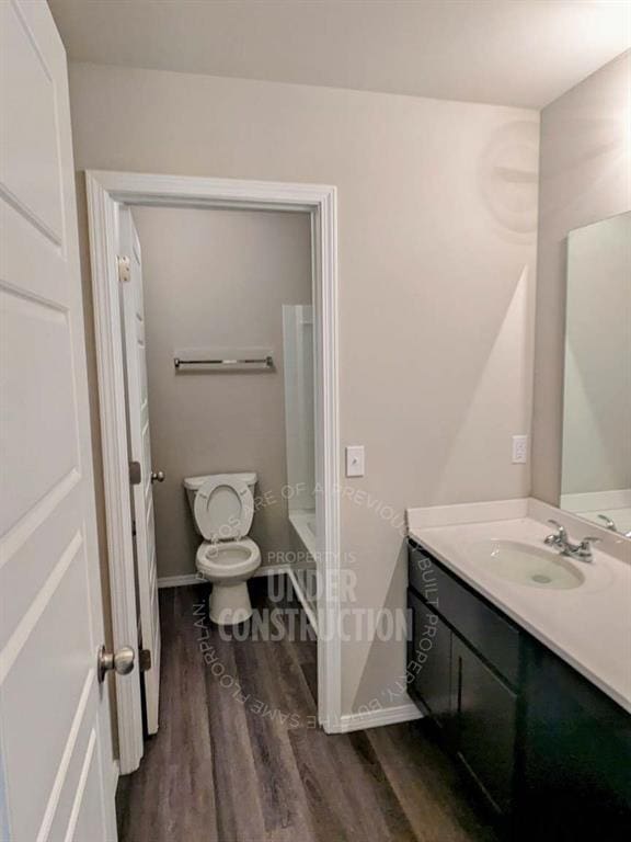 bathroom featuring hardwood / wood-style flooring, vanity, and toilet