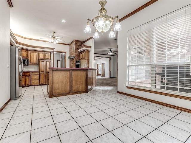 kitchen with appliances with stainless steel finishes, pendant lighting, light tile patterned floors, and crown molding