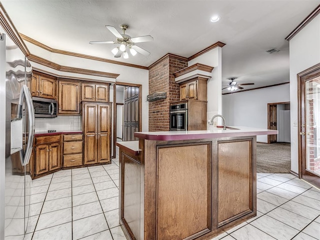 kitchen featuring stainless steel appliances, ceiling fan, ornamental molding, and sink