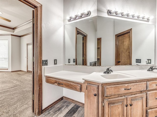 bathroom with wood-type flooring, vanity, and ornamental molding