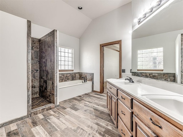 bathroom with hardwood / wood-style floors, vanity, separate shower and tub, and lofted ceiling