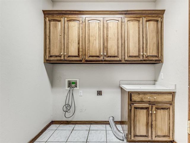 laundry room with cabinets, hookup for a washing machine, light tile patterned floors, and electric dryer hookup