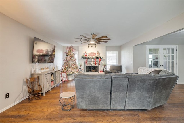 living room with a fireplace, ceiling fan, french doors, and dark hardwood / wood-style floors