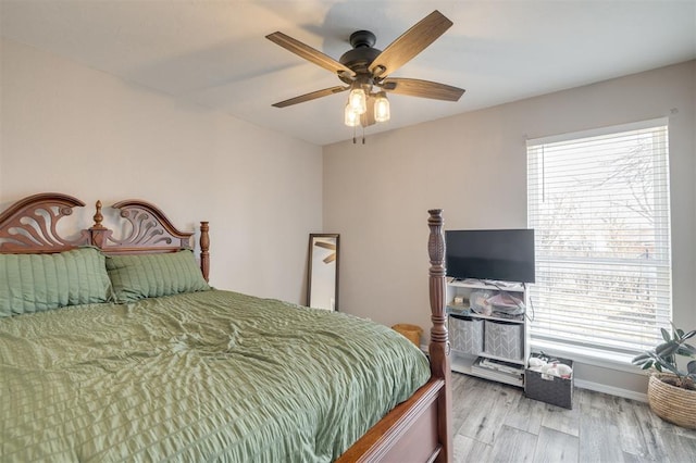 bedroom with ceiling fan, light wood-type flooring, and multiple windows