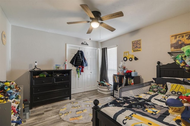 bedroom featuring ceiling fan, a closet, and light wood-type flooring