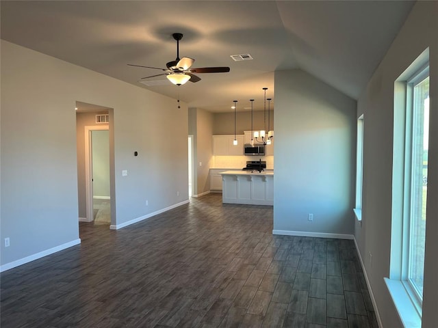 unfurnished living room featuring ceiling fan, dark wood-type flooring, and vaulted ceiling