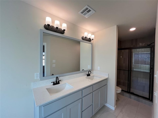 bathroom with vanity, toilet, and a shower with shower door