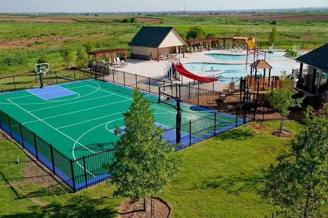 view of basketball court featuring a rural view, community basketball court, and fence