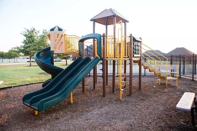 community jungle gym featuring a lawn and fence