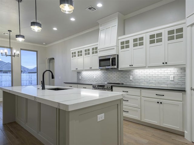 kitchen featuring sink, decorative light fixtures, a center island with sink, and appliances with stainless steel finishes