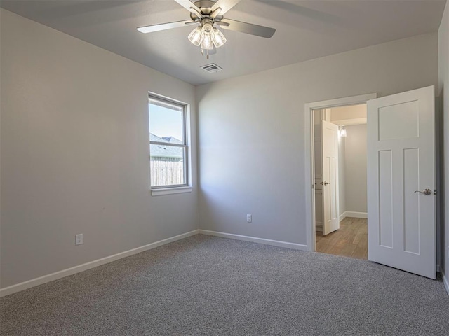 carpeted spare room featuring ceiling fan