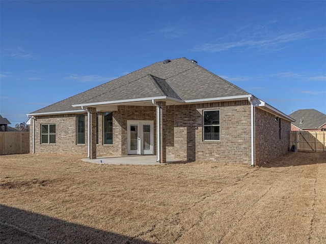 rear view of house featuring french doors, a patio area, and a lawn