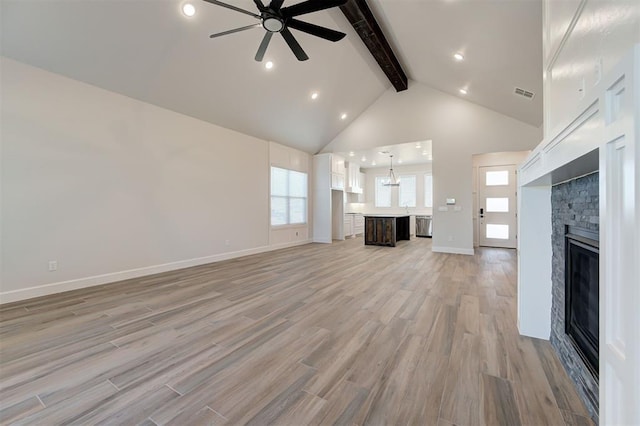 unfurnished living room with a stone fireplace, high vaulted ceiling, light hardwood / wood-style flooring, ceiling fan, and beam ceiling