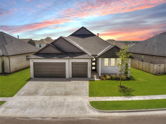 view of front of home with a garage and a yard