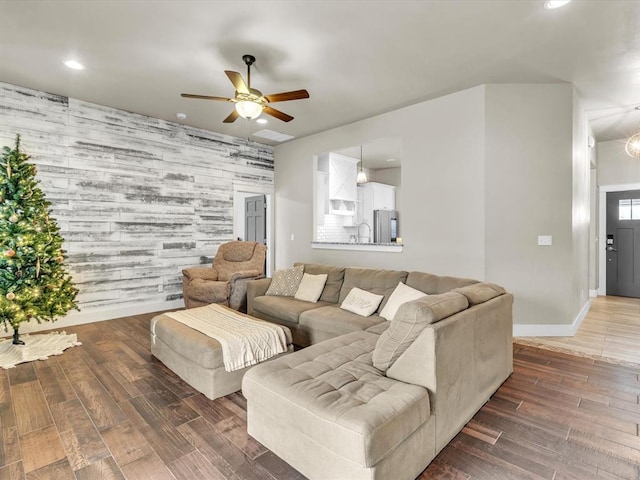 living room with dark hardwood / wood-style floors, ceiling fan, and sink