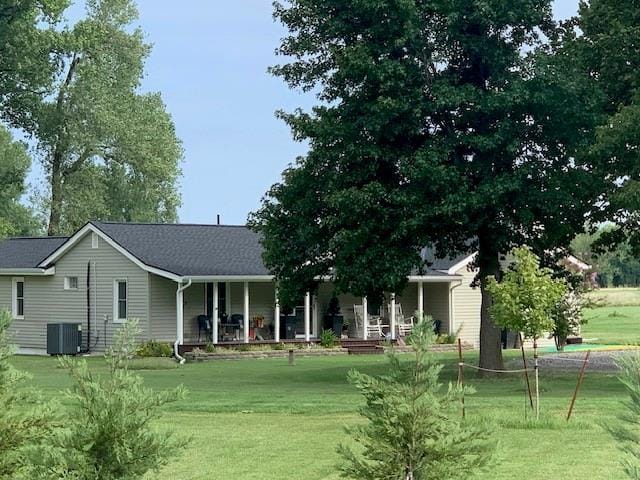 view of front facade featuring a front lawn and central air condition unit