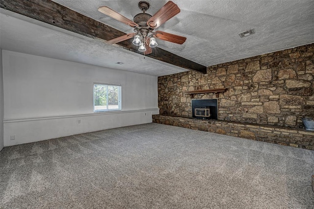 unfurnished living room featuring carpet flooring, a textured ceiling, and a wood stove