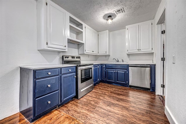 kitchen with blue cabinetry, white cabinetry, stainless steel appliances, dark hardwood / wood-style floors, and a textured ceiling