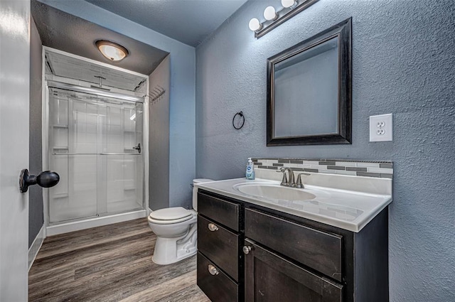 bathroom with toilet, vanity, wood-type flooring, and walk in shower