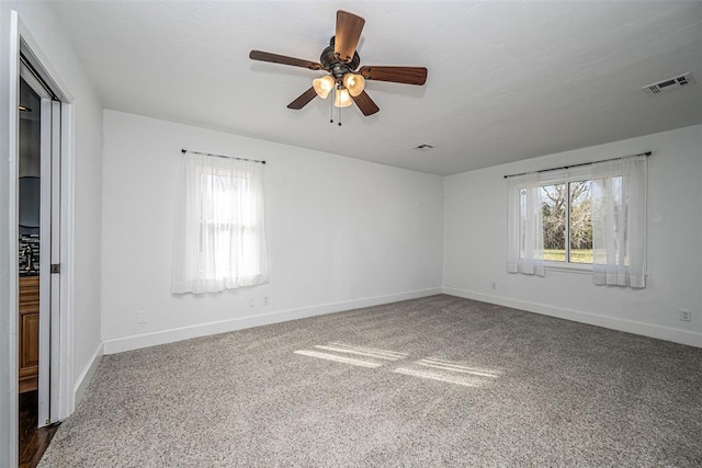 carpeted spare room featuring ceiling fan