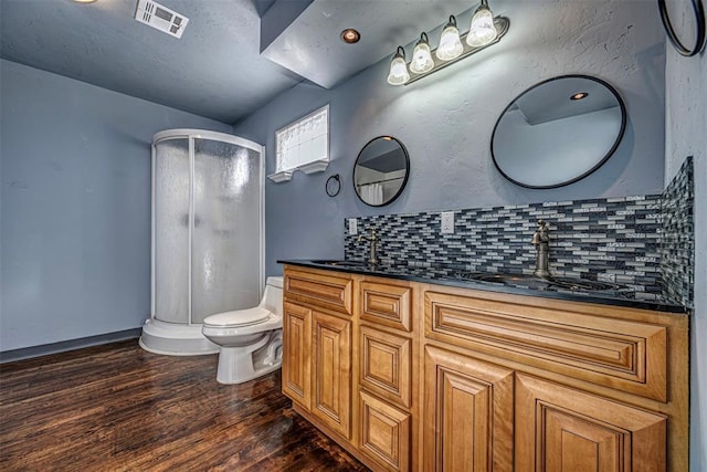 bathroom with vanity, decorative backsplash, wood-type flooring, and a shower with door