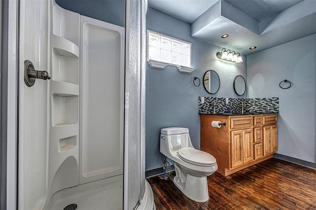 bathroom with toilet, hardwood / wood-style floors, vanity, and walk in shower