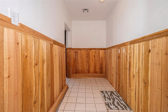 stairway featuring tile patterned flooring and wooden walls