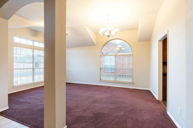 carpeted empty room featuring a wealth of natural light, a chandelier, and lofted ceiling