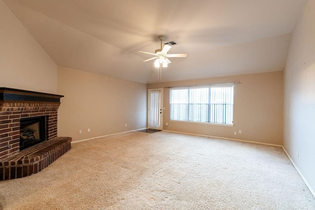 unfurnished living room featuring carpet, a brick fireplace, vaulted ceiling, and ceiling fan